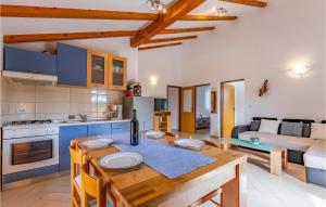 a kitchen and living room with a wooden table in a room at Beautiful Home In Marcana With 4 Bedrooms, Wifi And Outdoor Swimming Pool in Marčana