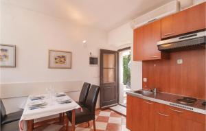 una cucina con tavolo, lavandino, tavolo e sedie di One-Bedroom Apartment In Pucisca a Pučišća