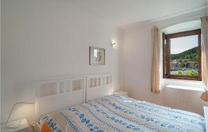 una camera da letto bianca con un letto e una finestra di One-Bedroom Apartment In Pucisca a Pučišća Altre 8 foto