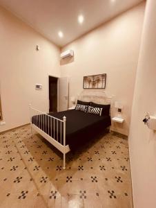 Schlafzimmer mit einem schwarz-weißen Bett in der Unterkunft B&B Meliora Rooms in Avola