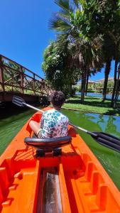 un homme assis à l'arrière d'un bateau dans l'eau dans l'établissement Golf Ville Resort Brisa do Golf -Apartamentos e Cobertura, à Aquiraz