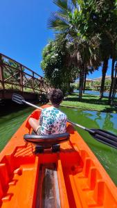 un hombre sentado en la parte trasera de un barco en el agua en Golf Ville Resort Brisa do Golf -Apartamentos e Cobertura, en Aquiraz