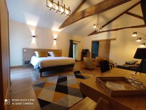 a bedroom with a bed and a living room at Domaine de l'Orfraie in Saint-Juire-Champgillon