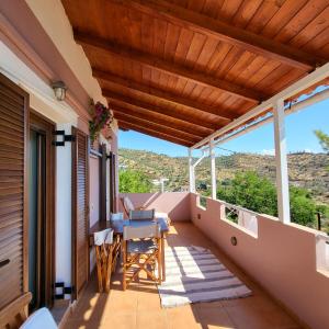 a balcony of a house with a table and chairs at Filanthi's Retreat In Mani's Nature in Krini Peloponnese