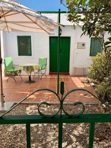 um pátio com uma mesa, cadeiras e um guarda-sol em Casa Anita - La Almona Chica em El Chorro