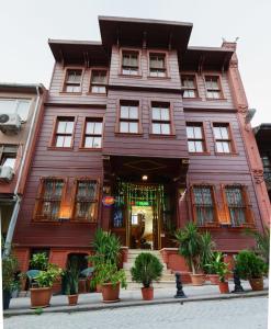 um grande edifício de madeira com plantas em frente em Le Safran Suite Hotel em Istambul