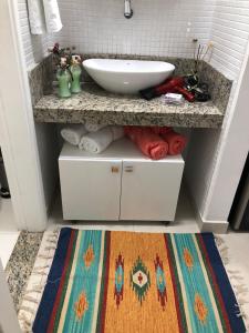 a bathroom with a counter with a sink and a rug at Conforto E Localizacao in Salvador