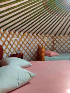 1 dormitorio con 2 camas en una yurta en Yourtes Lacroutz en Nassiet