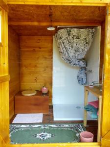 - une petite salle de bains avec baignoire dans une maison en bois dans l'établissement Yourtes Lacroutz, à Nassiet