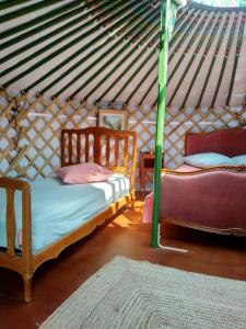 um quarto com duas camas numa tenda em Yourtes Lacroutz em Nassiet
