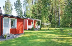 a red and white house in a yard with trees at Amazing Home In Sffle With Kitchen in Säffle