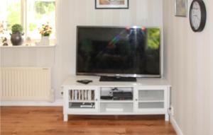 a flat screen tv sitting on a white entertainment center at Amazing Home In Sffle With Kitchen in Säffle