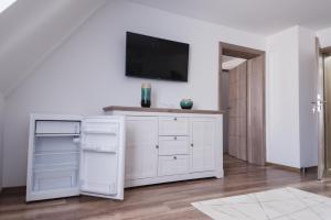 a white kitchen with a tv on a wall at Vila Helena in Sibiu