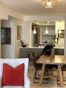 a dining room and kitchen with a table and a red pillow at Canal Quays 507 in Cape Town