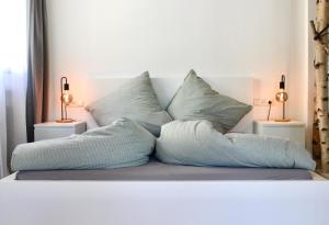 un sofá blanco con almohadas encima en Vier Sind Hier Apartments, en Rottweil