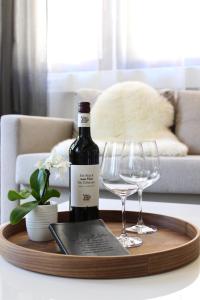 una botella de vino en una bandeja de madera con copas de vino en Vier Sind Hier Apartments en Rottweil