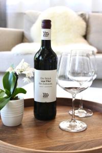 una botella de vino y una copa en una mesa en Vier Sind Hier Apartments en Rottweil