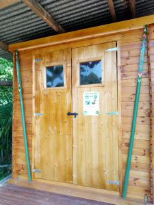 a wooden shed with a door and two windows at Yourtes Lacroutz in Nassiet