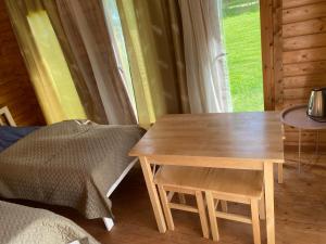 a wooden table and stool in a room with a window at Peipsi Talu majake in Rootsiküla