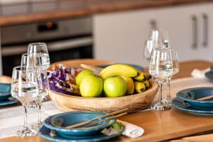 a table with a bowl of fruit on a table with glasses at G&M House in Kefalás