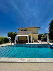 uma villa com piscina em frente a uma casa em Villa Solemar em Briatico