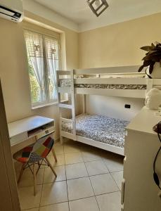Zimmer mit 2 Etagenbetten, einem Schreibtisch und einem Stuhl in der Unterkunft Villa Solemar in Briatico