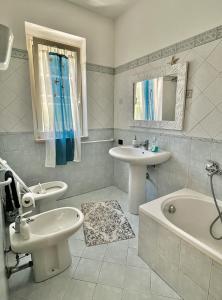 a bathroom with a sink and a toilet and a bath tub at Villa Solemar in Briatico
