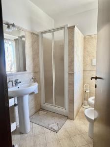 a bathroom with a shower and a sink and a toilet at Villa Solemar in Briatico