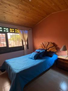 蒙圭的住宿－Hospedaje Aquitoy Sanoha，一间卧室配有一张带蓝色床单的床和一扇窗户。