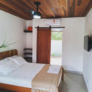 um quarto com uma cama e uma janela em Hakuna Studios Barra do Sahy em Barra do Sahy