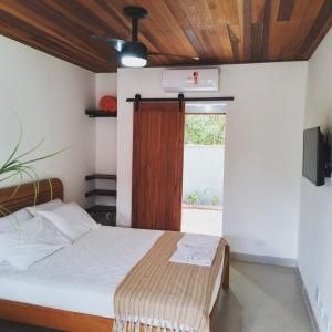 a bedroom with a bed and a window at Hakuna Studios Barra do Sahy in Barra do Sahy