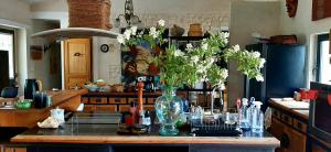 a kitchen with a vase of flowers on a counter at Aux Tuileries Nord in Créon