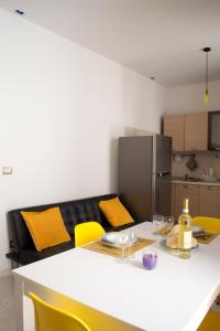 une cuisine avec une table blanche et des chaises jaunes dans l'établissement Casa Vacanze - Il Balconcino, à Iglesias
