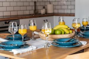 a table with glasses of orange juice and a bowl of fruit at G&M House in Kefalás