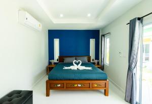 Un dormitorio con una cama con una cinta. en Coco Sea Bangpo Resort, en Ban Bang Po