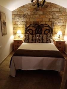 - une chambre avec un grand lit et 2 tables de chevet dans l'établissement Casa Cueva Soledad, à Guadix