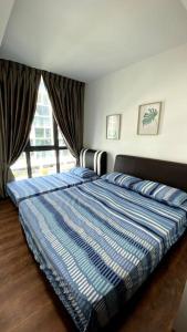a bedroom with a bed with a blue comforter and a window at #2.1 Jazz Suites Large Bed Vivacity Kuching 3rooms in Kuching