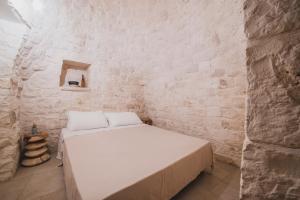 um quarto com uma cama numa parede de tijolos em Dimorae Camà em Cisternino