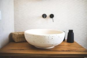 チステルニーノにあるDimorae Camàの木製のテーブルの上に置かれた白い鉢