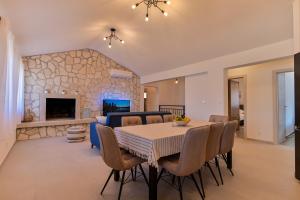 a dining room with a table and a fireplace at Villa Rudini with heated pool in Okrug Gornji