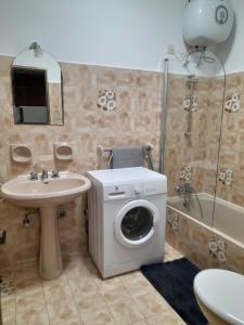 un bagno con lavatrice e lavandino di Gozo Marsalforn a Marsalforn