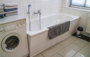 e bagno con vasca bianca e lavatrice. di Lovely Apartment In Krakow Am See With Kitchen a Krakow am See