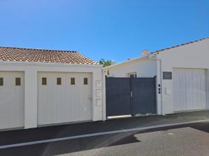 two garages with gates in a parking lot at Appartement Aix (1 à 2 personnes) in Châtelaillon-Plage