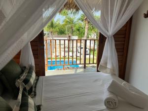 - une chambre avec un lit et une vue sur la piscine dans l'établissement Vila Bless 4 bedroom Vila with pool, garden and beach tennis court, à Prea