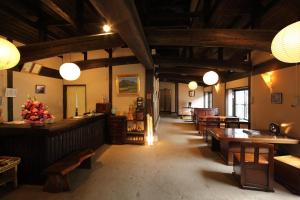 a restaurant with wooden ceilings and tables and chairs at Tawarayama Onsen Ryokan Minawa in Minami Aso