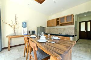 Seminyak Villa في سمينياك: مطبخ مع طاولة خشبية في الغرفة