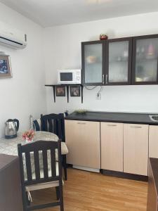 een keuken met een aanrecht en een tafel met een stoel bij Villa Flora SP apartments in Ravda