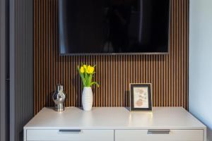 a white cabinet with a vase with yellow flowers on it at Hillside7 Micro-Apartment 7 in Bielsko-Biała