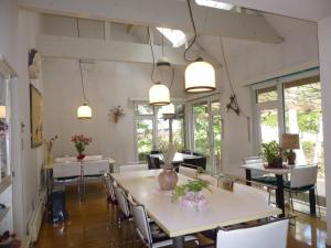a dining room with tables and chairs and windows at St Village in Hokuto
