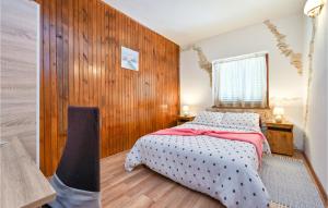 - une chambre avec un lit et un mur en bois dans l'établissement Lovely Home In Gornja Reka With Wifi, à Lokošin Dol